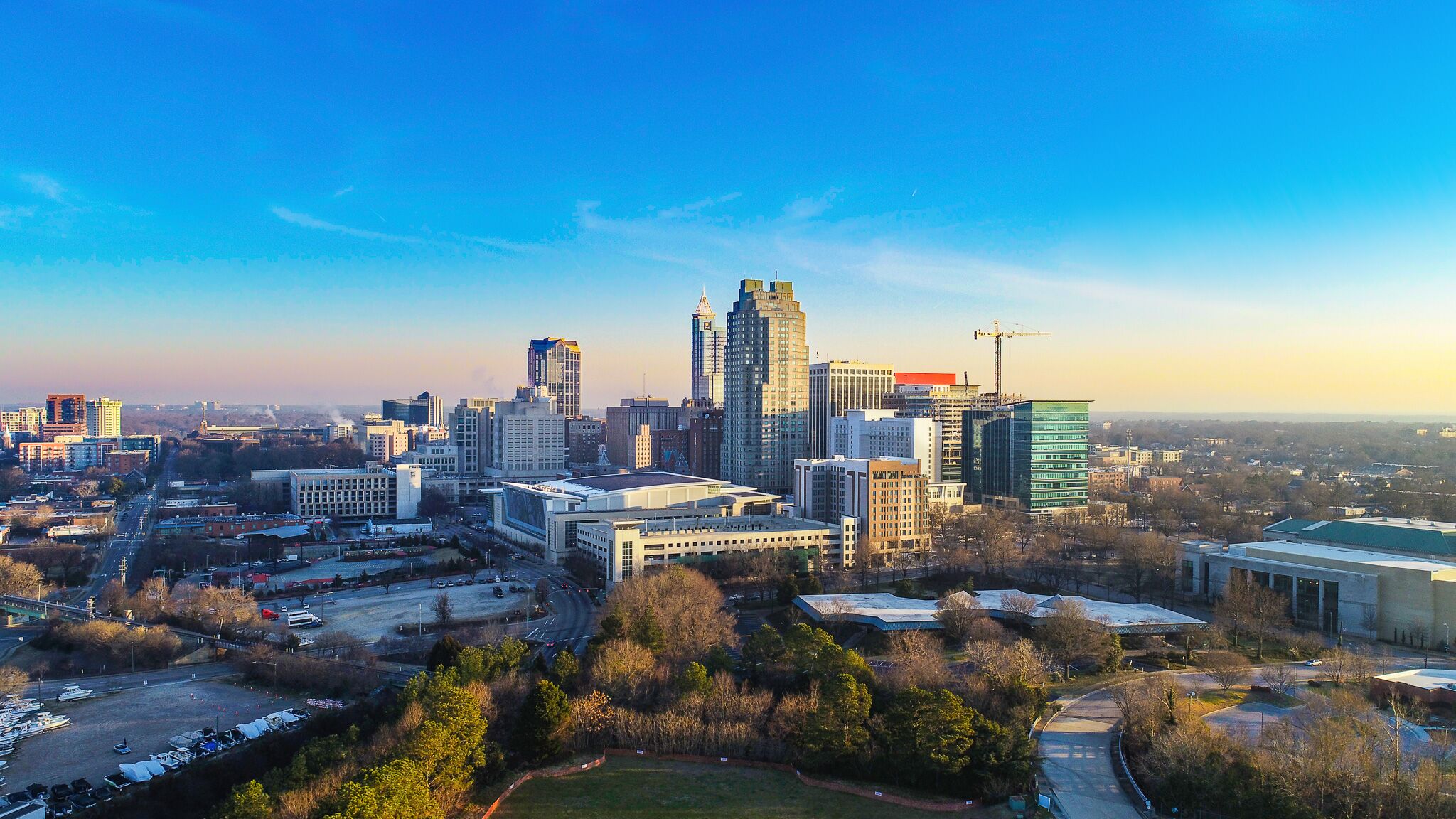 An aerial view of the downtown Raleigh skyline at golden hour, the heart of North Carolina's Research Triangle.